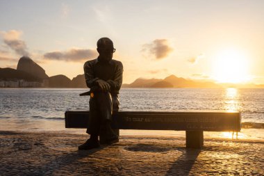 Şair heykeli için güzel bir gün doğumu manzarası Copacabana, Rio de Janeiro, Brezilya plaj bankında oturuyor.