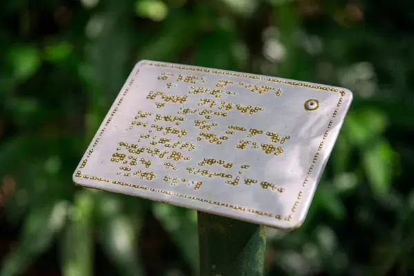Metalowy Znak Napisami Alfabecie Braille Dla Niewidomych Zielonym Lesie Deszczowym — Zdjęcie stockowe