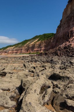 Brezilya 'nın Rio Grande do Norte eyaletinde kayalıkları ve turuncu kumlu kayalıkları olan vahşi Baa dos Golfinhos plajına güzel bir manzara 