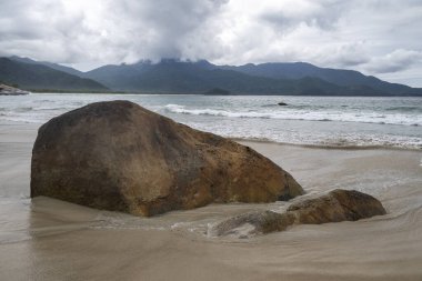 Plaj kayaları, dağlar ve Aventureiro Plajı 'ndaki ağır bulutlar, Ilha Grande, Rio de Janeiro, Brezilya