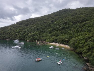 Feiticeira Sahili 'ne güzel hava manzarası, kayalar, yeşil yağmur ormanları ve zümrüt suları üzerindeki tekneler, Ilha Grande, Rio de Janeiro, Brezilya