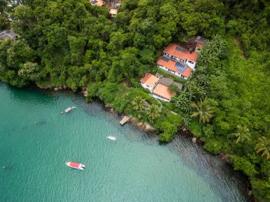 Okyanus üzerindeki yeşil yağmur ormanları için güzel bir hava manzarası küçük ahşap iskelede teknesi olan Ilha Grande, Rio de Janeiro, Brezilya