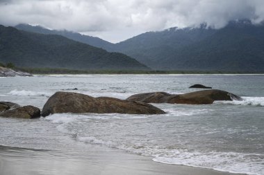 Plaj kayaları, dağlar ve Aventureiro Plajı 'ndaki ağır bulutlar, Ilha Grande, Rio de Janeiro, Brezilya