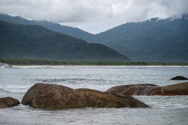 Plaj kayaları, dağlar ve Aventureiro Plajı 'ndaki ağır bulutlar, Ilha Grande, Rio de Janeiro, Brezilya