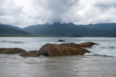 Plaj kayaları, dağlar ve Aventureiro Plajı 'ndaki ağır bulutlar, Ilha Grande, Rio de Janeiro, Brezilya