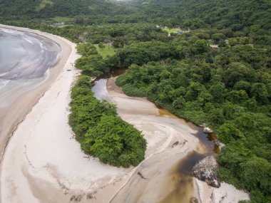 Dois Rios plajının sol tarafındaki yeşil yağmur ormanı nehrinin güzel hava manzarası, Ilha Grande, Rio de Janeiro, Brezilya