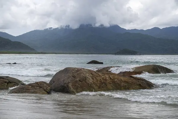 Plaj kayaları, dağlar ve Aventureiro Plajı 'ndaki ağır bulutlar, Ilha Grande, Rio de Janeiro, Brezilya