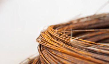 Paslı metal kabloların detaylı yakın plan görüntüsü oksitlenmenin karmaşık dokularını gösteriyor. Odak noktası birbirine dolanmış kablolar, nötr, açık renkli bir arka plan ile