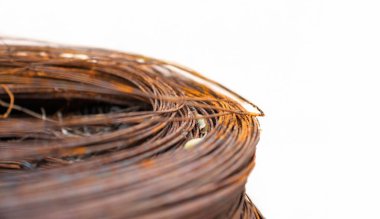 Çürümeyi ve aşınmayı vurgulayan paslanmış metal kabloların yakın çekim görüntüsü. Kablolar dairesel bir şekil oluşturuyor, paslanmış olanın sert yapısına zıt, pürüzsüz bir ışık arkaplanı var.