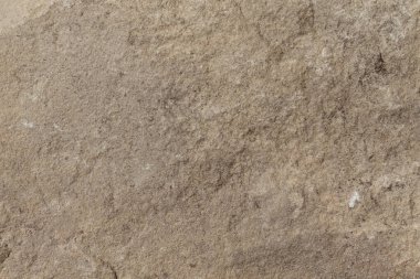 Kırsal ve organik tasarımlar için uygun, dokulu detaylar ve engebeli kusurları gösteren doğal kahverengi bir taş yüzey..