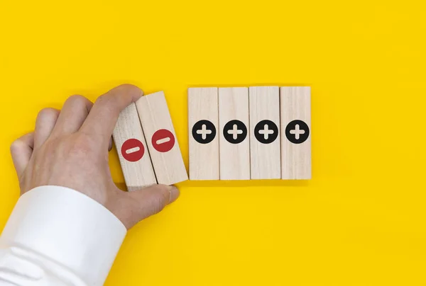 Plus and minus icons on wooden cubes. Separate the negative from positive, removing the weaknesses or negativity, positive thinking, negative feedback or subtraction