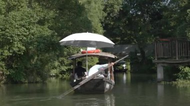 Hangzhou, Zhejiang, Çin 'de elle yapılan geleneksel bir tekne gezisi. Yüksek kalite 4k görüntü