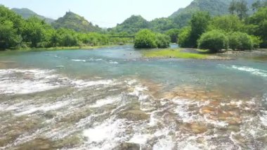 Wenzhou, Zhejiang, Çin 'deki Nanxi Nehri turistik bölgesindeki yüksek dağların ve nehrin havadan görüntüsü. Yüksek kalite 4k görüntü