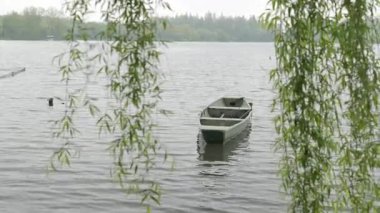 Hangzhou 'daki Batı Gölü' nde yüzen tahta tekneler büyüleyici doğal manzarayla çevrili. Yüksek kalite 4k görüntü