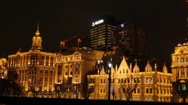 Shanghai Bund ve Lujiazui gece aydınlandı, ikonik gökdelenler, finansal bölge silueti, ve Huangpu Nehri üzerindeki göz kamaştırıcı yansımalar.