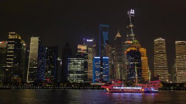 Shanghai Bund ve Lujiazui gece aydınlandı, ikonik gökdelenler, finansal bölge silueti, ve Huangpu Nehri üzerindeki göz kamaştırıcı yansımalar.