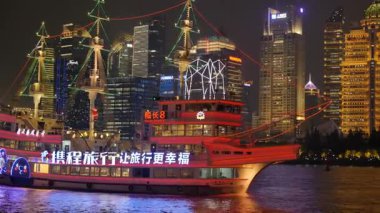 Shanghai Bund ve Lujiazui gece aydınlandı, ikonik gökdelenler, finansal bölge silueti, ve Huangpu Nehri üzerindeki göz kamaştırıcı yansımalar.