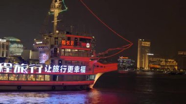 Shanghai Bund ve Lujiazui gece aydınlandı, ikonik gökdelenler, finansal bölge silueti, ve Huangpu Nehri üzerindeki göz kamaştırıcı yansımalar.