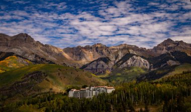 Colorado 'daki San Juan Dağları' nın canlı yaprakları arasında lüks bir dağ tatil köyü sessizce duruyor. Arka planda engebeli sırtlar gerilirken, ormanlık yamaçlar öğleden sonra ışığı altında parlarken, bir dinginlik ve sakinlik yaratıyor.. 