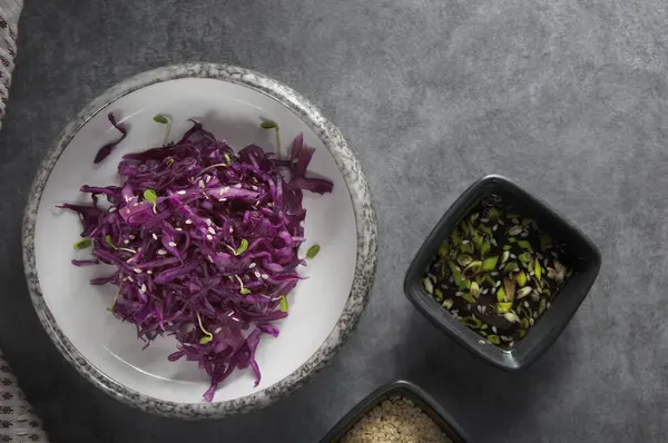 Red cabbage salad with sesame seeds, micro greens and sauce