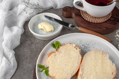 Kahvaltı, ekmek ve tereyağı. Klasik tarzda beton bir masada çekilmiş..