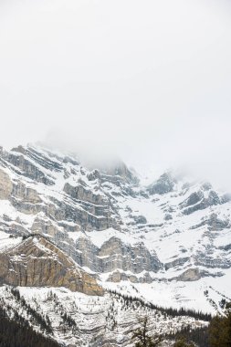 Kar ve sisle kaplı dik dağ sıraları görkemli bir kış görünüşü ve hissi yaratıyor.