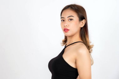 Siyah tek omuzlu genç kadın kameraya özgüvenle bakıyor. Hafif makyaj ve temiz fon ile.