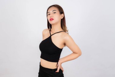 Siyah bluzlu, kendine güvenen genç bir kadın, beyaz arka planda el üstünde poz veriyor.