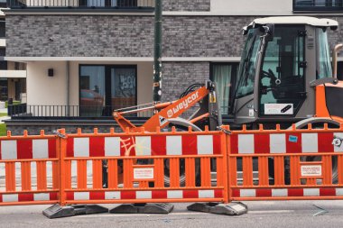 Gerresheimer caddesinde yeni yapılmış apartmanların önünde inşaat traktörü.