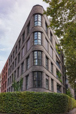 Yuvarlak pencereli ve tuğladan cepheli modern köşe binası