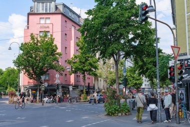 Pembe bina ve kafe manzaralı canlı Köln caddesi köşesi