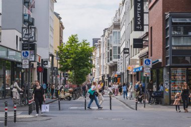 Giyim mağazaları, kafeler ve kitapçılarla dolu bir alışveriş caddesi (Breite Caddesi)