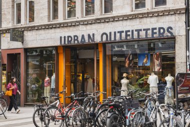 Urban Outfitters vitrininde mankenler ve park edilmiş bisikletler var.