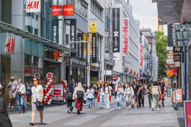 Köln 'deki Hohe Caddesi' nde dükkanlar ve yürüyen insanlar var.
