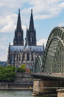 Arka planda Köln Katedrali olan Ren Nehri 'nden Hohenzollern Köprüsü' nü geçen insanlar.