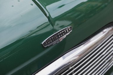 Austin Cooper rozetinin yakın plan resmi. Parlak yeşil, eski bir araba üzerinde.