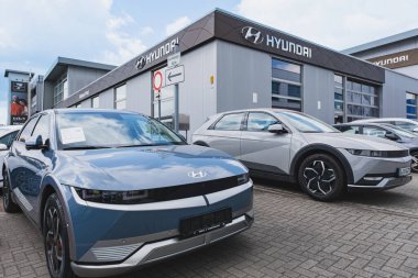 Modern Hyundai elektrikli arabaları bir bayilik binasının önüne park edilmiş.