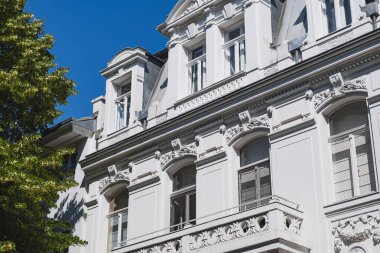 Dekoratif pencere detaylarıyla tarihi beyaz bina cephesini süsleName