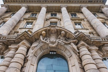 Süslü heykelleri ve sütunları olan tarihi taş bina