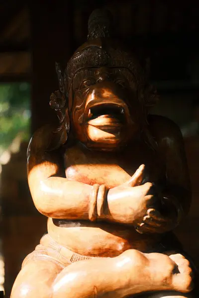 Bali mitolojisinden mizahi ve grotesk bir karakter olan Sangut 'u resmeden geleneksel bir Bali ahşap heykeli, ağzı açık ve belirgin bir ifadeyle yakın plan çekilir.