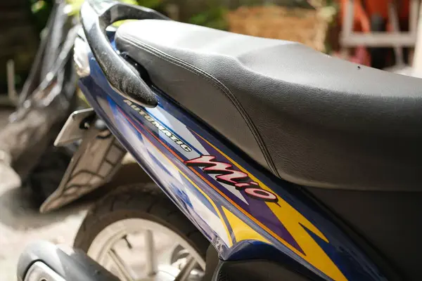 Denpasar, Bali - 07 Mayıs 2025: Bu resim Yamaha Mio motorsikletinin arka kısmının, dokulu koltuğu ve hareketli vücut grafiklerini gösteren, kentsel ulaşımın yaygın bir biçimini ortaya koyan zarif tasarımını yakalıyor.