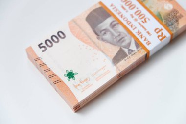 Pekanbaru, Endonezya - 21 Mart 2025: Endonezya rupia Rp 5.000 banknot yığını Kurban Bayramı veya Lebaran günleri için THR için beyaz arka planda izole edildi