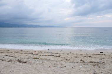 Dili, Timor Leste - 7 Ocak 2022: Plastik kirliliği tropik bir plaj boyunca yayıldı