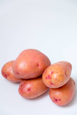 Beyaz arkaplanda kırmızı patatesin seçici odak noktası