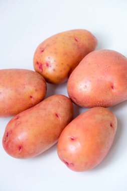 Beyaz arkaplanda kırmızı patatesin seçici odak noktası