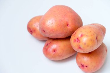 Beyaz arkaplanda kırmızı patatesin seçici odak noktası