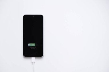 Hızlı şarj modunda şarj edilen cep telefonu pili beyaz arkaplanda izole ediliyor