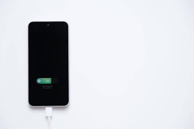 Hızlı şarj modunda şarj edilen cep telefonu pili beyaz arkaplanda izole ediliyor
