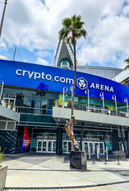 Los Angeles, California USA - 25 Mayıs 2025: crypto.com arena, LA Liveve, Downtown. Dan Meis, mimar. Star Plaza girişi, Chick Hearn Caddesi, Elgin Baylor Heykeli, palmiye ağaçları, parçalı bulutlu mavi gökyüzü