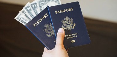 İçinde Amerikan doları banknotları olan iki Amerikan pasaportu seyahat ve mali durumu temsil ediyor..
